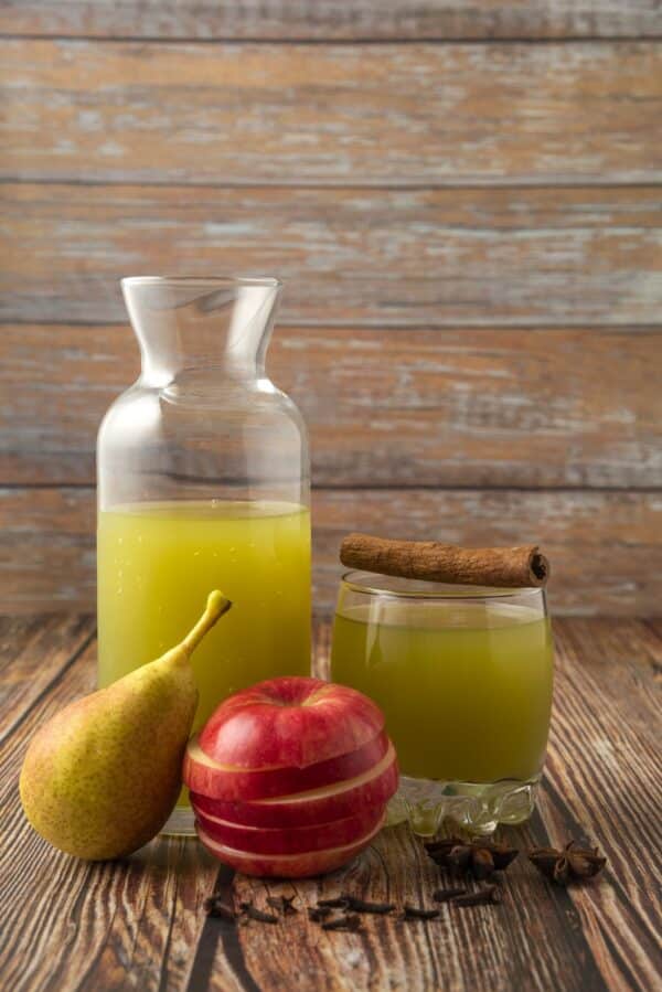 Green pear and red apple with a glass of juice